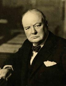 Photographie (noir et blanc) ; portrait de Winston Churchill, tête et haut du corps, assis à un bureau