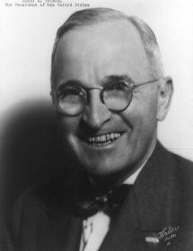 homme en buste souriant avec des lunettes