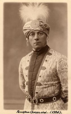 Ahmed en buste et de face, dans un costume d’inspiration orientale. À la veste et à la ceinture richement ornées