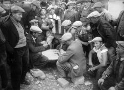 Dans la cour d'une usine occupée dans la région parisienne, les grévistes jouent aux cartes en 1936