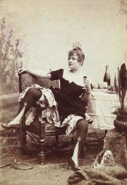 La Goulue, femme assise avec une cigarette et verre de vin dans les mains