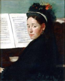 La jeune pianiste, très coquettement vêtue d’un chapeau à fleurs et à plumes