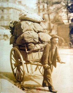 le chiffonnier s’apprête à repartir, sa charrette pleine de sacs de détritus. 