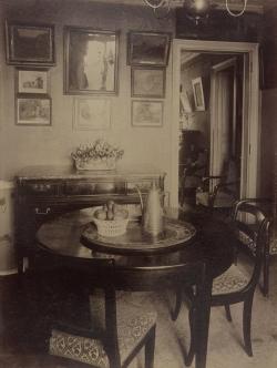 intérieur avec une table et des chaises, une corbeille de fruit et une verseuse