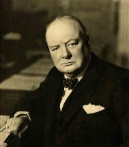 Photographie (noir et blanc) ; portrait de Winston Churchill, tête et haut du corps, assis à un bureau