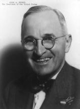 homme en buste souriant avec des lunettes