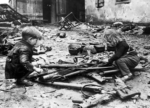 Enfants français jouant avec des armes laissées par l'armée allemande lors de sa retraite